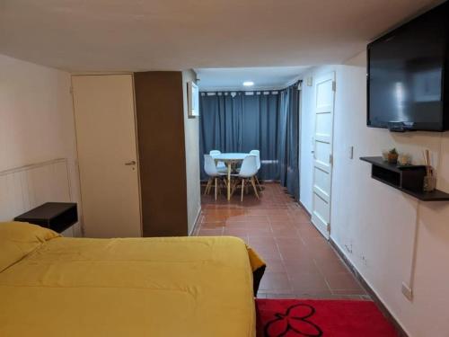 a hotel room with a yellow bed and a table at Depto la falda Cordoba in La Falda