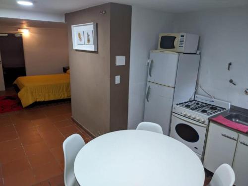 a small kitchen with a stove and a refrigerator at Depto la falda Cordoba in La Falda