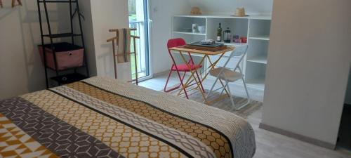Chez Elisa في شينون: غرفة نوم بسرير وطاولة وكراسي