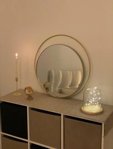 a mirror on top of a counter with a candle at The place to B&B - vue lac, 3 chambres et parking privé in Évian-les-Bains