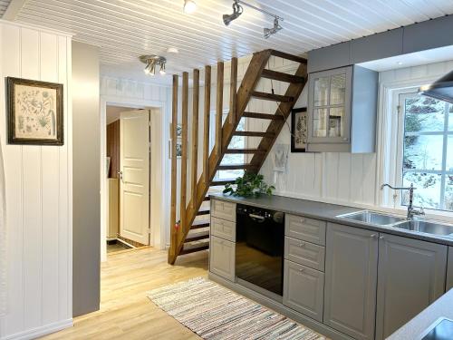 a kitchen with a spiral staircase in the background at The Buar Cabin in Strömstad