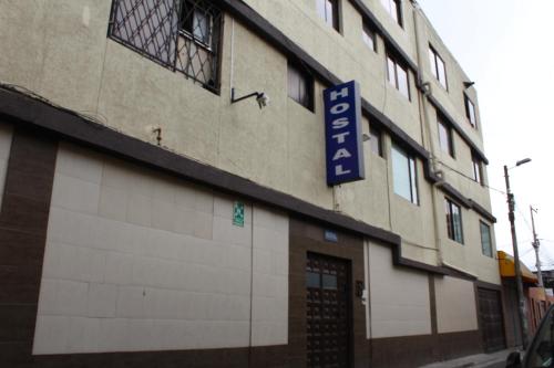 um edifício com um sinal azul no lado em JULIUS Hostal -NO PARQUEO, Alojamiento desde las 14 horas hasta 12 mediodía- em Quito