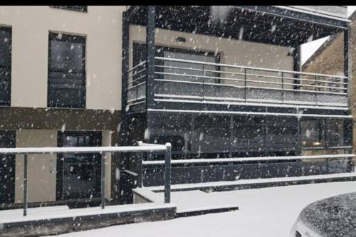 a snow storm in front of a building at Appartement Terrasse 4 personnes in Les Rousses