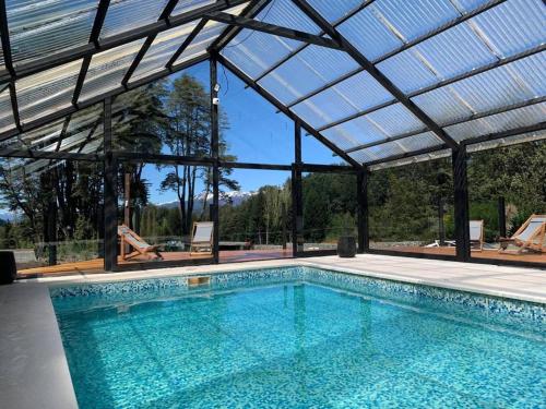 una piscina cubierta con techo de cristal en Del Caballero Hotel en Villa La Angostura