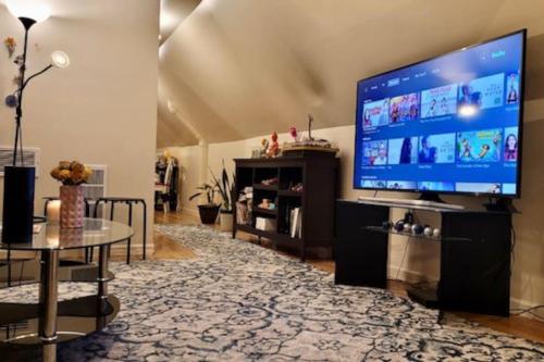 a living room with a large flat screen tv at Entire 1 Bedroom Top Floor Rental Unit with Patio in Chicago