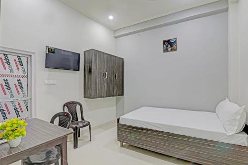 a bedroom with a bed and a table and chairs at SSK Hotel in Lucknow