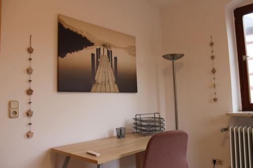 a desk with a chair and a picture on the wall at Geräumige Idylle im Grünen bei Bamberg in Walsdorf