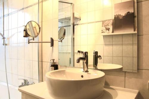 a white bathroom with a sink and a mirror at Geräumige Idylle im Grünen bei Bamberg in Walsdorf