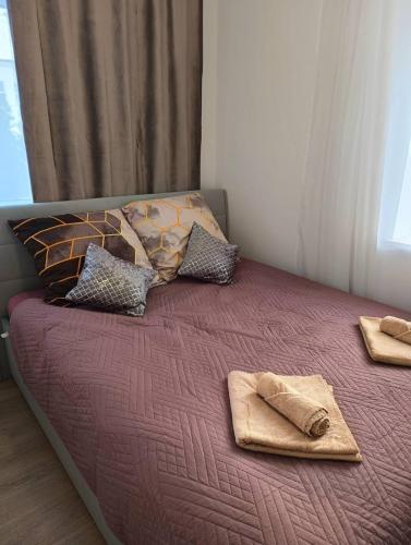 a bed with blankets and pillows on top of it at MH Apartment Rzeszów in Rzeszów