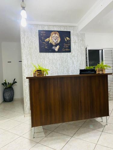 a reception desk with a picture of a lion on the wall at HOSTEL ANPRADO in Guarulhos