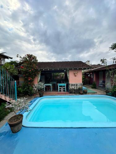 a swimming pool in front of a house at Vila Luiza Ubatuba in Ubatuba