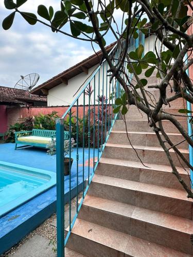 a staircase next to a swimming pool next to a house at Vila Luiza Ubatuba in Ubatuba