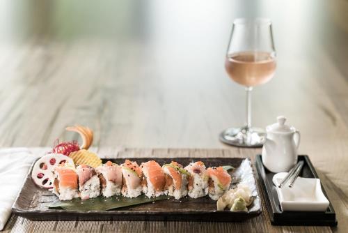 a plate of sushi and a glass of wine at Innovation Hotel in Naples