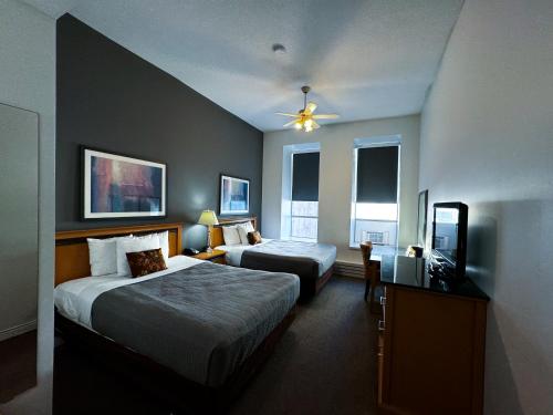 Una habitación de hotel con dos camas y un televisor. en The Met Hotel, en New Westminster