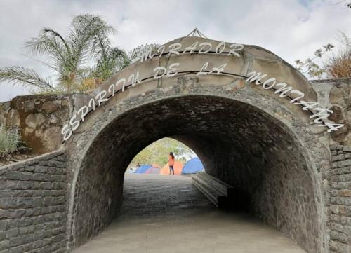 a stone archway with a person walking through it at Spirit Mountain/El Espíritu de la Montaña in La Unión