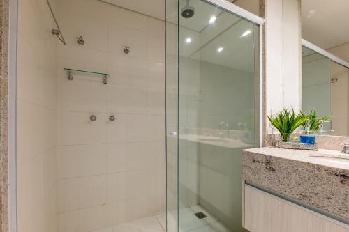 a bathroom with a glass shower and a sink at Studios Exclusivos Xavishome Granja Brasil Itaipava in Itaipava