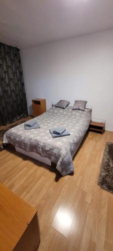 a large bed in a room with a wooden floor at Studio BDN in Sîngeorgiu de Mureş