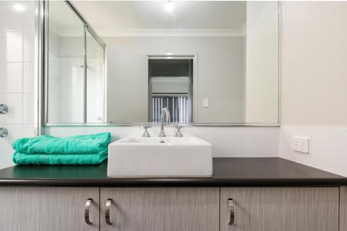 ein Bad mit einem Waschbecken und einem Spiegel in der Unterkunft West Swan B&B in Perth