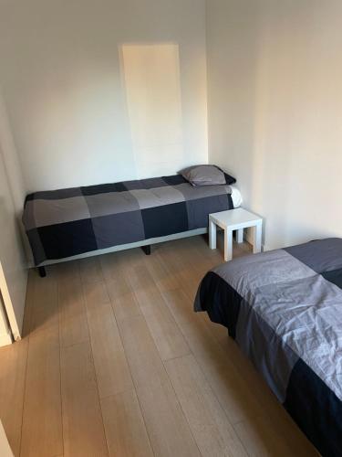 een slaapkamer met 2 bedden en een tafel. bij Apartment in Brussels City with Beautiful View in Brussel