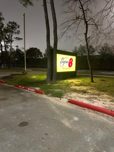 a sign for a store on the side of a road at Super 8 by Wyndham The Woodlands North in The Woodlands