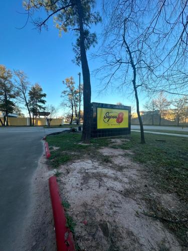 a sign sitting on the side of a road at Super 8 by Wyndham The Woodlands North in The Woodlands