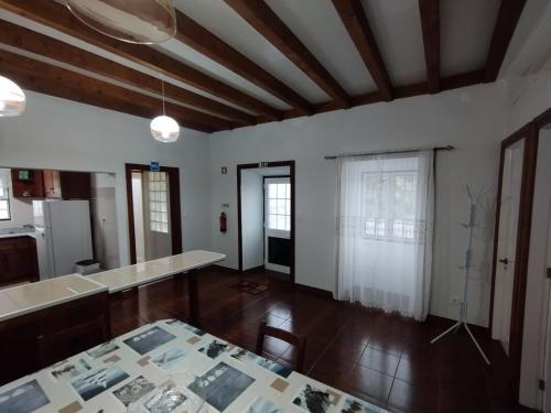 een woonkamer met een tafel en een keuken bij Casa das Palmeiras in Lajes das Flores