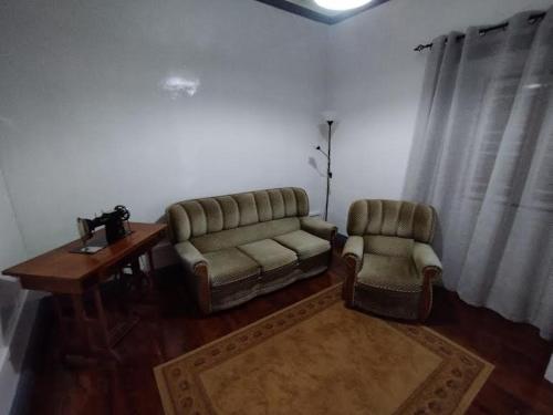 sala de estar con sofá y 2 sillas en Casa das Palmeiras, en Lajes das Flores