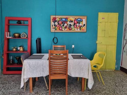 uma sala de jantar com mesa e cadeiras e uma parede azul em Casa La Ermita em San Benito