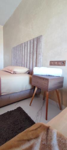a bedroom with a bed and a table in it at surf house Agadir in Tama ou Ennza