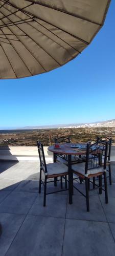 two picnic tables and chairs sitting on a patio at surf house Agadir in Tama ou Ennza