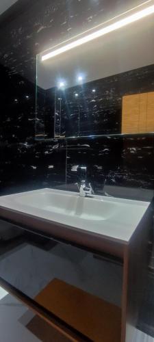 a bathroom with a white sink and a mirror at surf house Agadir in Tama ou Ennza