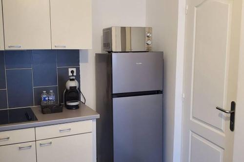 Il comprend une cuisine équipée d'un réfrigérateur et d'un four micro-ondes. dans l'établissement Tulsa Home - Appartement 1 chambre Cosy et calme, à Saint-Quentin