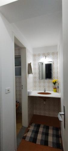 y baño con lavabo y espejo. en Apartamento Guarapari, en Guarapari