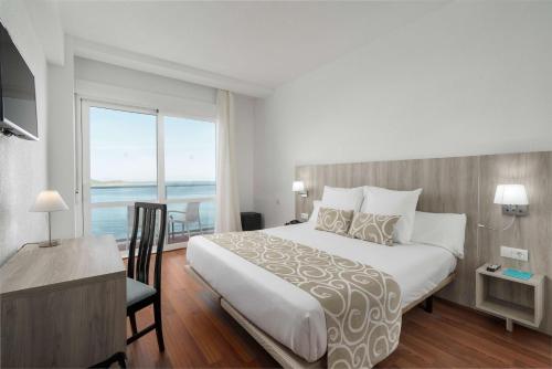 a bedroom with a large bed and a large window at AluaSun Doblemar in La Manga del Mar Menor