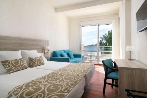 a hotel room with a bed and a desk and a window at AluaSun Doblemar in La Manga del Mar Menor