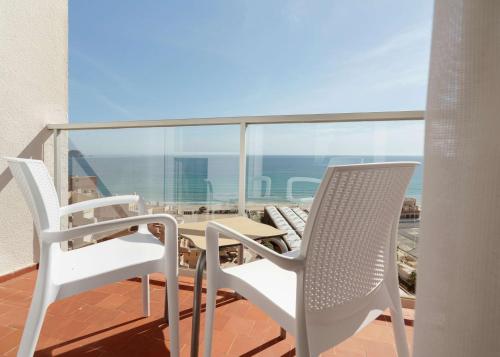 two chairs and a table on a balcony with the ocean at AluaSun Doblemar in La Manga del Mar Menor