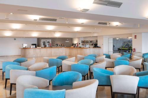 a restaurant with blue chairs and a bar at AluaSun Doblemar in La Manga del Mar Menor