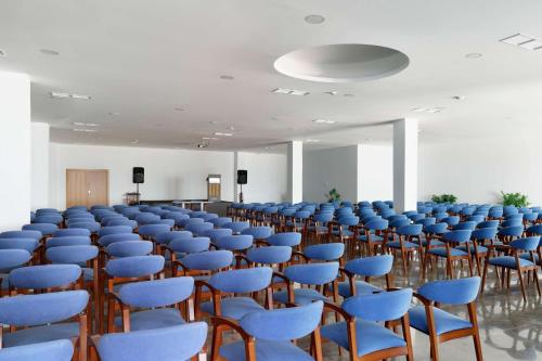 a large room with blue chairs and a podium at AluaSun Doblemar in La Manga del Mar Menor