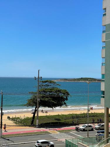 een uitzicht op een strand met auto's geparkeerd op een parkeerplaats bij ITAPARICA BEACH CLUB in Vila Velha
