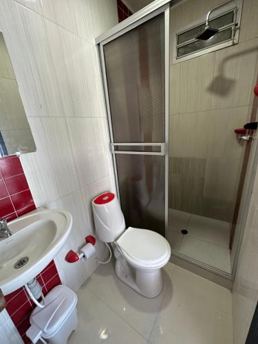 a bathroom with a toilet and a sink and a shower at Rio-ApartaHotel-Lagos in Leticia