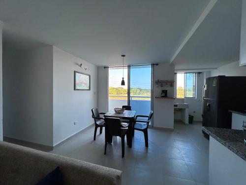 コベニャスにあるApartamento Caribe Coveñasのテーブルと椅子のあるキッチンとダイニングルーム