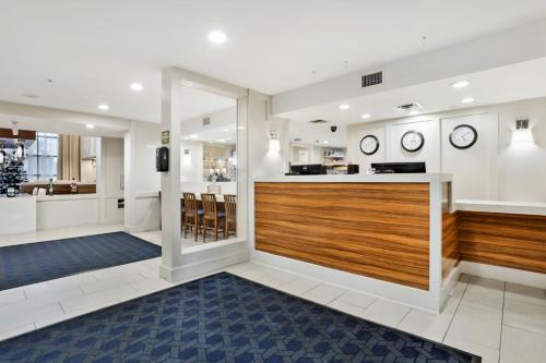 a lobby with a bar with clocks on the wall at Staybridge Suites Columbia - Baltimore by IHG in Columbia