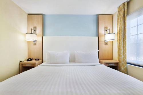 a bedroom with a large white bed and a window at Staybridge Suites Columbia - Baltimore by IHG in Columbia