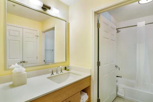 a bathroom with a sink and a mirror and a shower at Staybridge Suites Columbia - Baltimore by IHG in Columbia