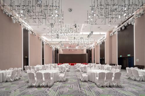 a banquet hall with white tables and chairs and chandeliers at Holiday Inn Taiyuan Sunshine by IHG in Taiyuan