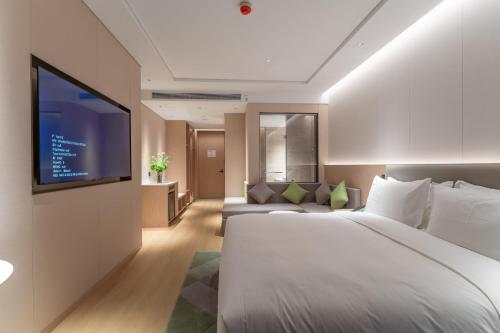 a hotel room with a bed and a flat screen tv at Holiday Inn Taiyuan Sunshine by IHG in Taiyuan