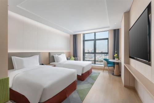 um quarto de hotel com duas camas e uma televisão de ecrã plano em Holiday Inn Taiyuan Sunshine, an IHG Hotel em Taiyuan