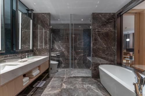 uma casa de banho com uma banheira, um lavatório e um chuveiro em Holiday Inn Taiyuan Sunshine, an IHG Hotel em Taiyuan