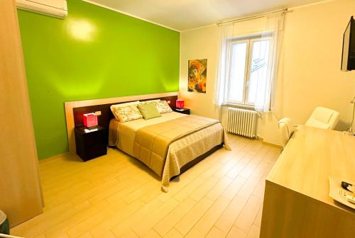 - une chambre verte avec un lit et une fenêtre dans l'établissement Fitta Camere Matera, à Matera