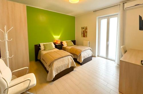 マテーラにあるFitta Camere Materaの緑の壁の客室で、ベッド2台が備わります。
